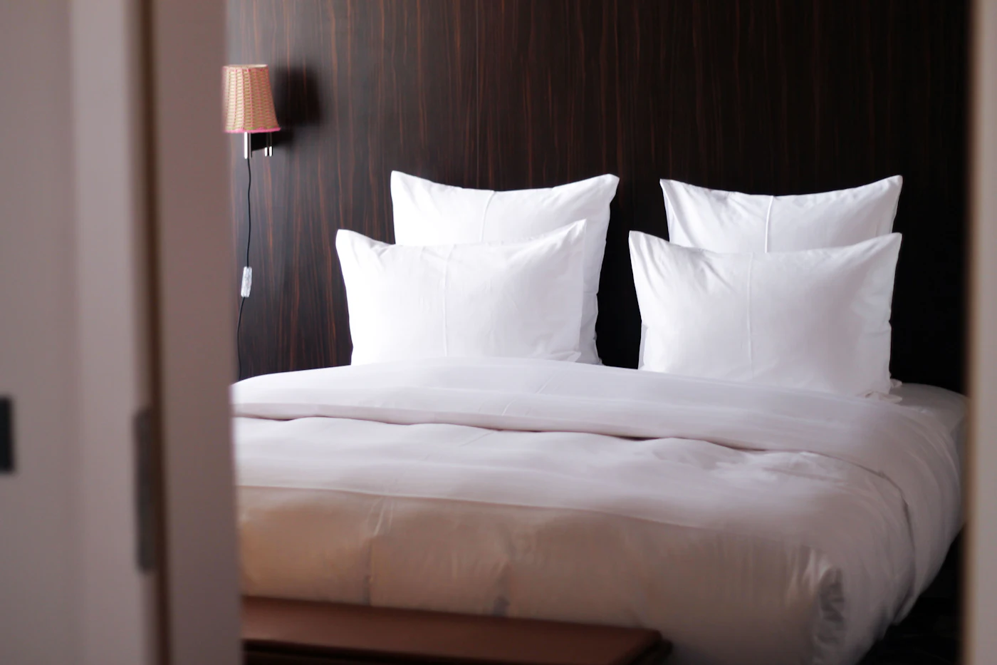 Lit Airbnb fait avec du linge blanc de qualité hôtelière