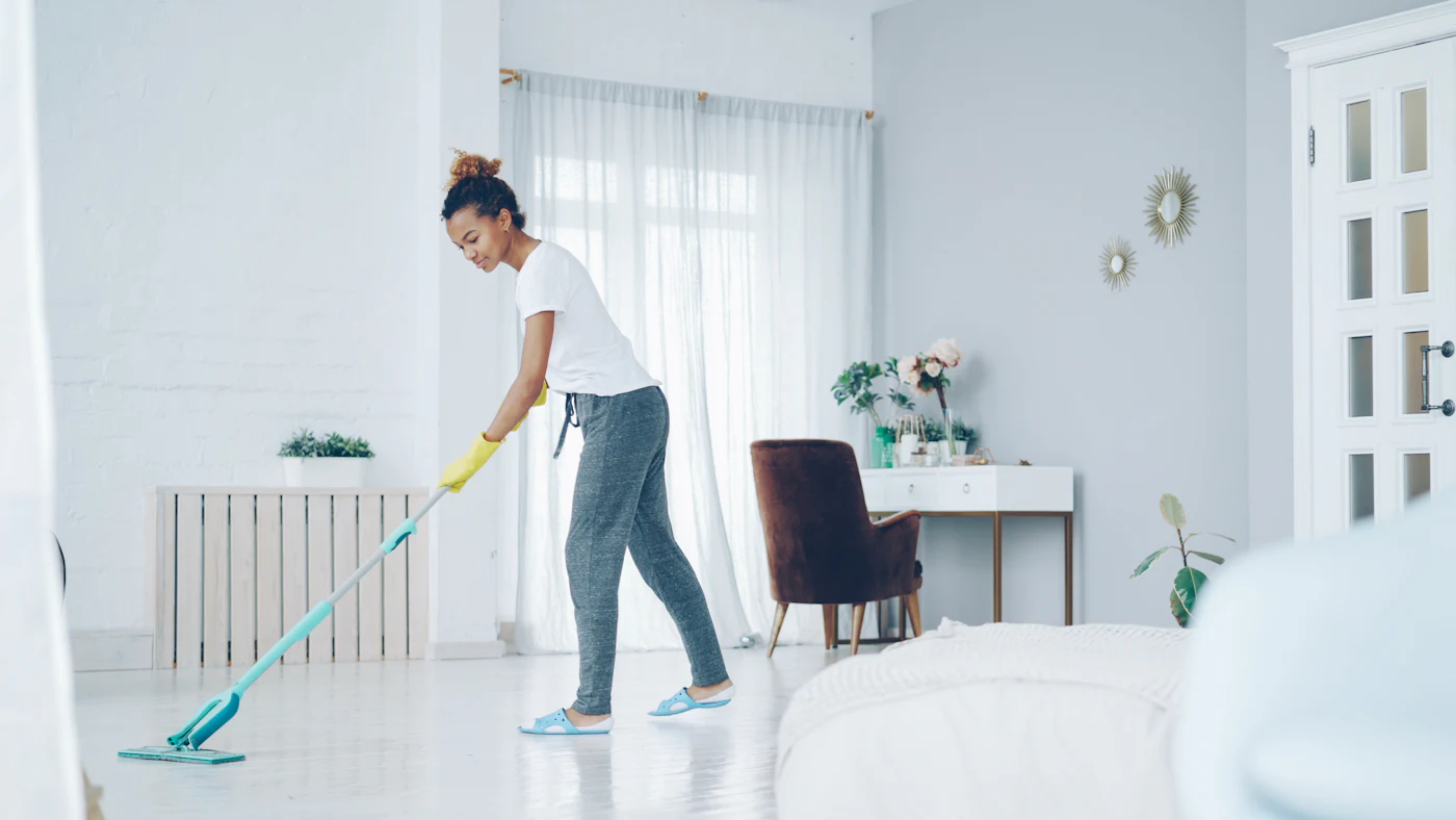 Agent d'entretien passant l'aspirateur dans un appartement Airbnb